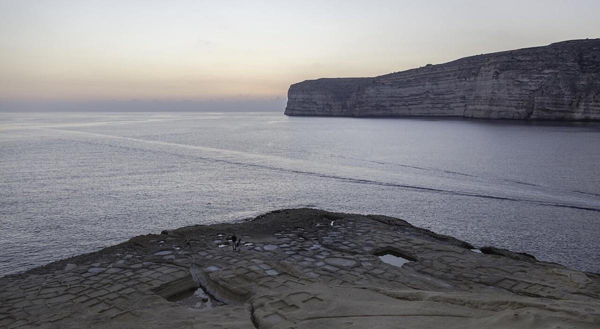 Xlendi Bay with its cliffs and clear water at dusk